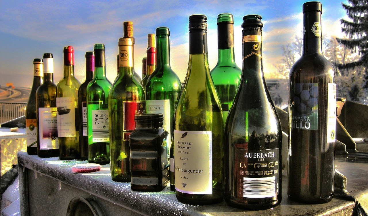 photo: pixabay Sixteen different coloured glass bottles stand on a waste container in winter.