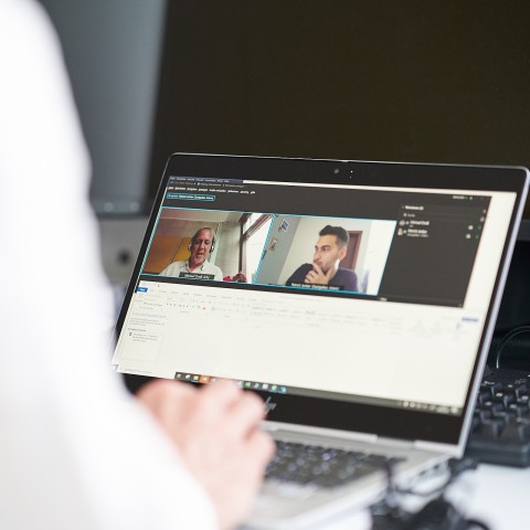 Foto eines Laptops mit Bildschirmkonferenz