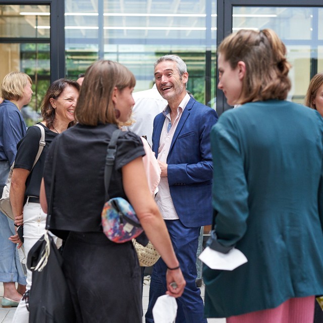 Mehrere Personen stehen beieinander und unterhalten sich.