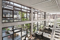 großer Arbeitsraum mit arbeitenden Menschen und großer Glasfront