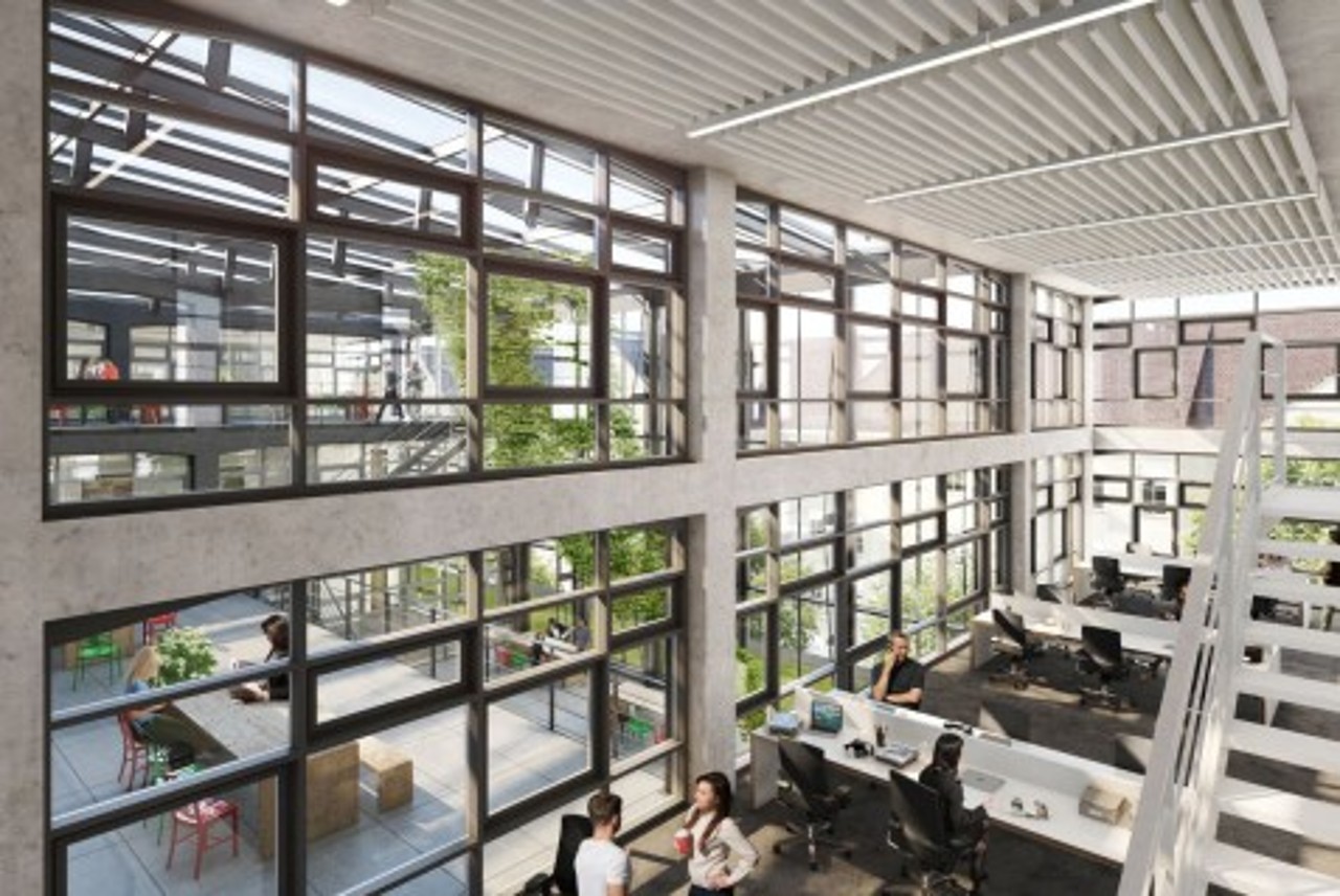 großer Arbeitsraum mit arbeitenden Menschen und großer Glasfront