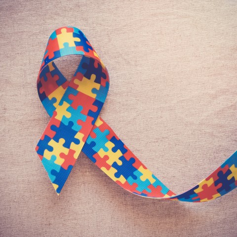 eine Schleife zeigt bunte Puzzlestücke