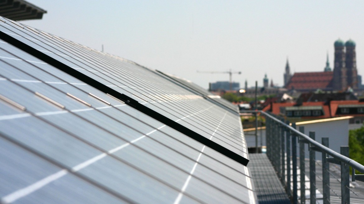Blick über Solarpanele auf dem Dach eines HM-Gebäudes zur Frauenkirche