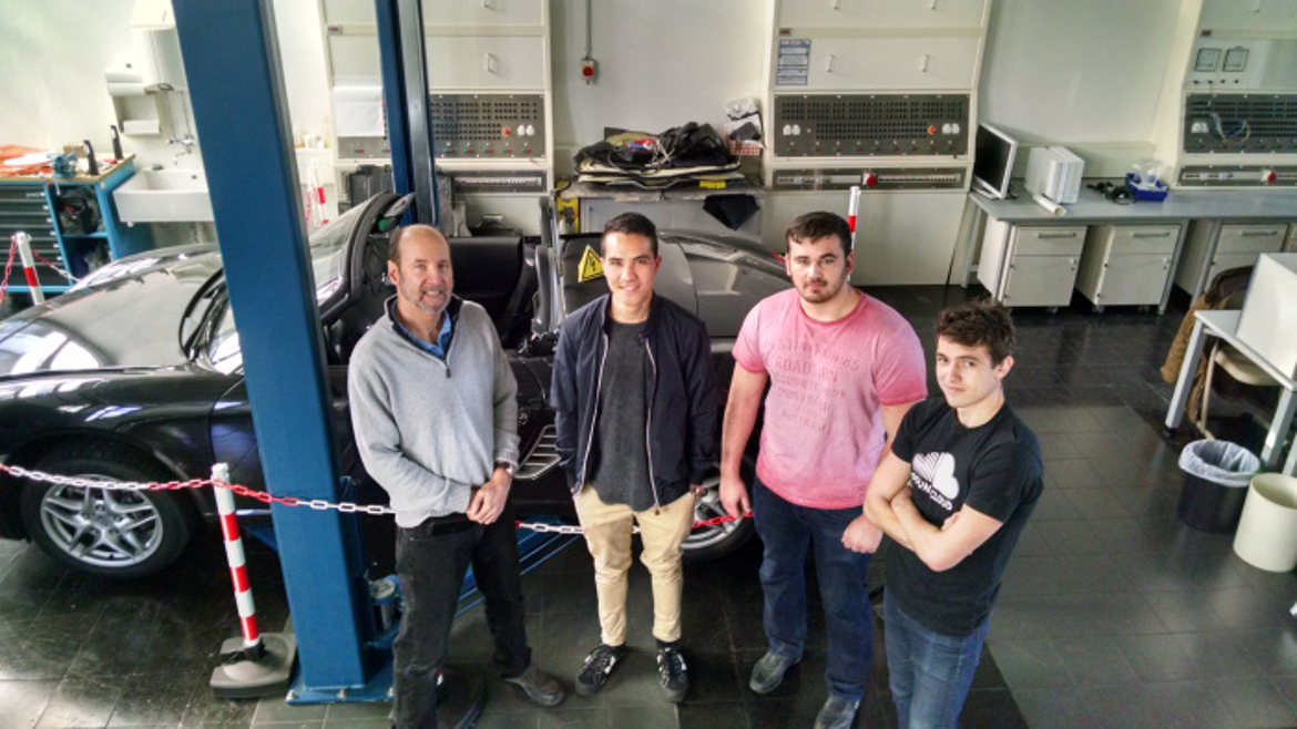 Professor from the partner university Cal Poly with three students in the lab.