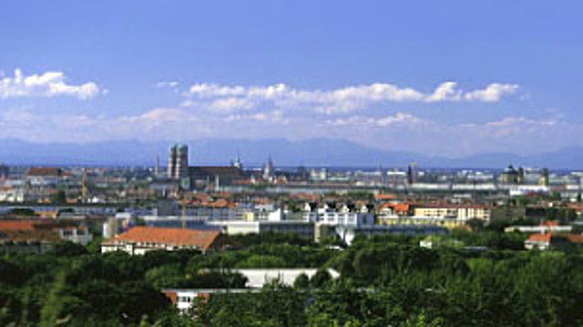 Im Hintergrund die Stadt München und die Alpenkulisse an einem sonnigen und blauen Tag, 