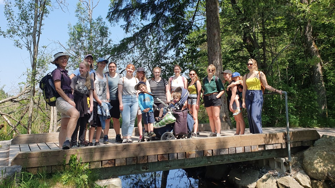 Bayernmentoring Stammtisch - Wandern im Juni 2023 (Foto: Karin Geretshauser) Studentinnen stehen auf einem Steg über einem Fluss im Wald