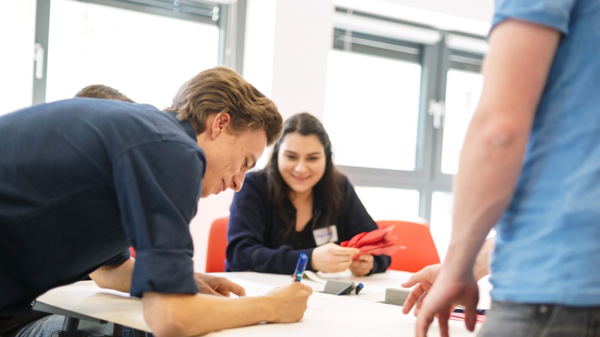 Studierender schreibt auf Papier