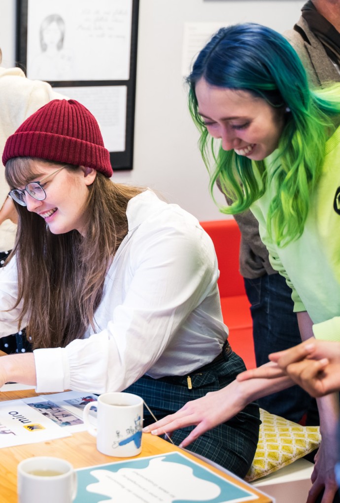 Studierende sitzen zusammen und lachen