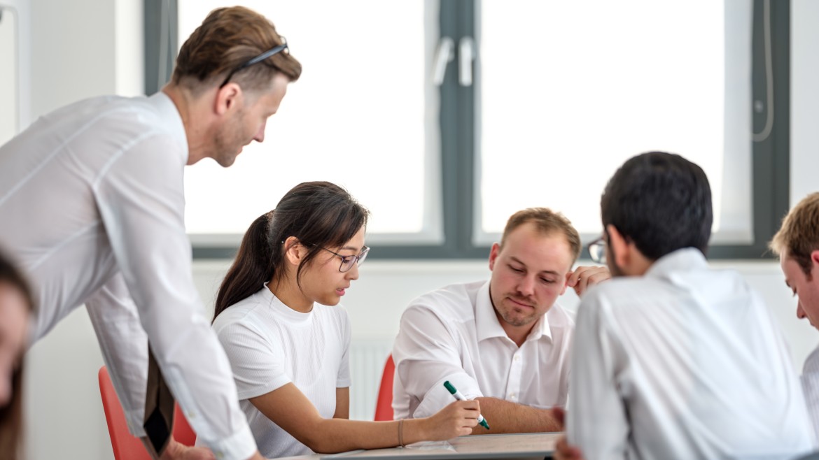 Studierende und Lehrender in Gruppenarbeit