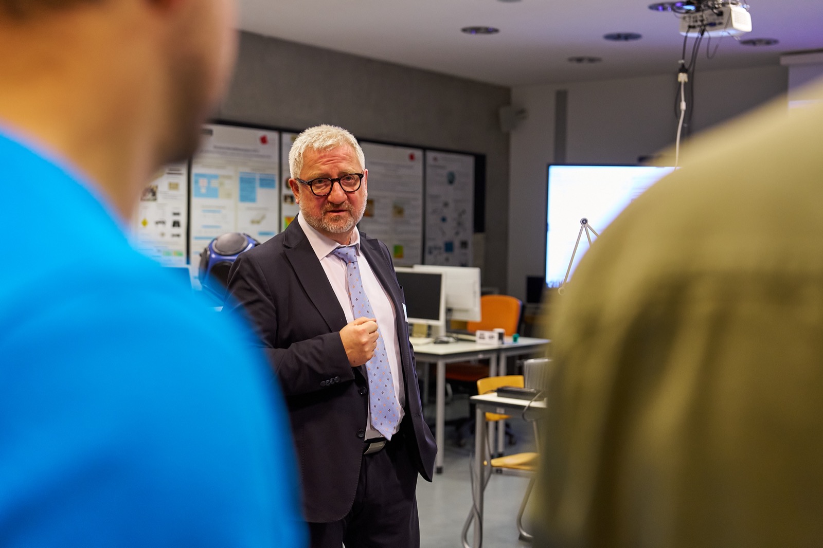 Herr Prof. Dr.-Ing. Sentpali erklärt Besucher:innen etwas.