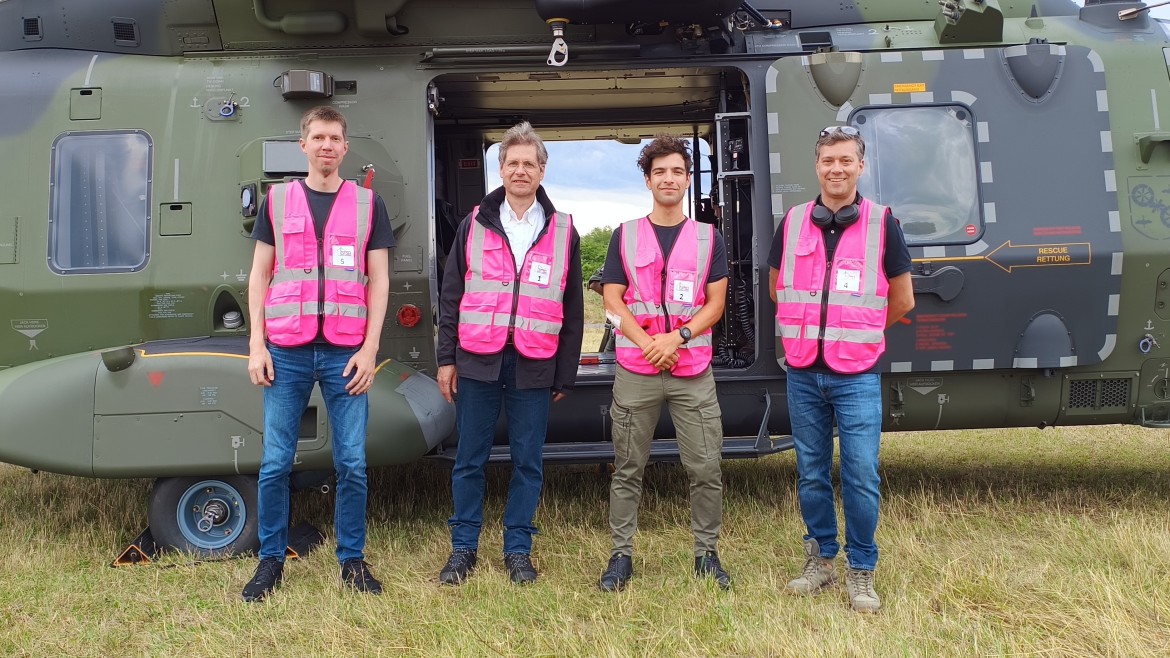 Vier Männer in pinken Warnwesten stehen vor Hubschrauber (Foto: Tobias Augustin) Vier Männer in pinken Warnwesten stehen vor Hubschrauber