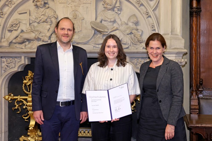 HM-Absolventin Laura Steffl erhält den Hochschulpreis der Stadt München 2025 für ihre Masterarbeit zum klimafreundlichen Straßenbau – zusammen mit HM-Professor Thorsten Stengel und Bürgermeisterin Verena Dietl.