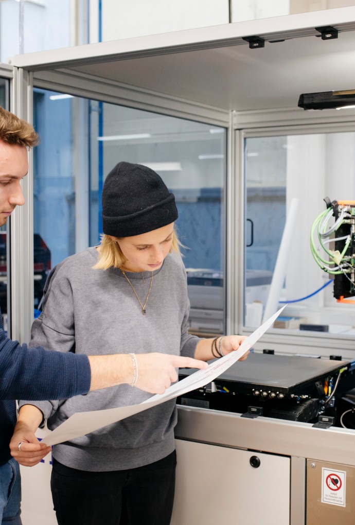Zwei Studierende vor Druckmaschine 