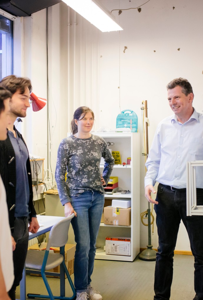 Professor mit Energie- und Gebäudetechnik-Studierenden im Labor 