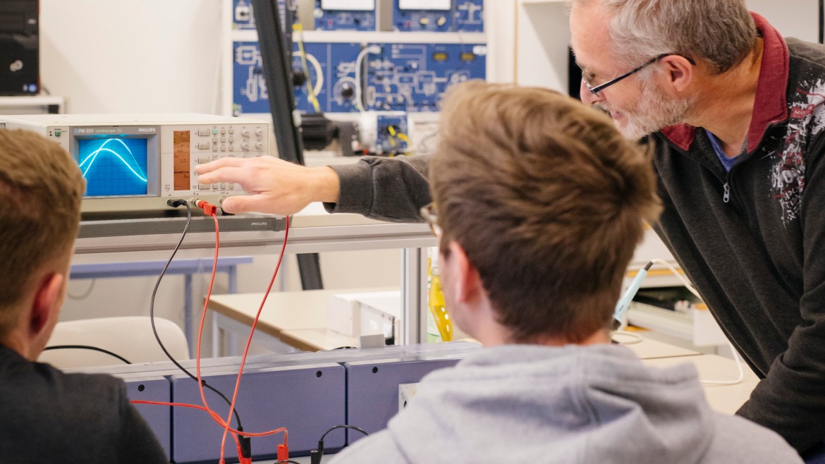 Studierende und Professor im Labor für elektrische Systeme