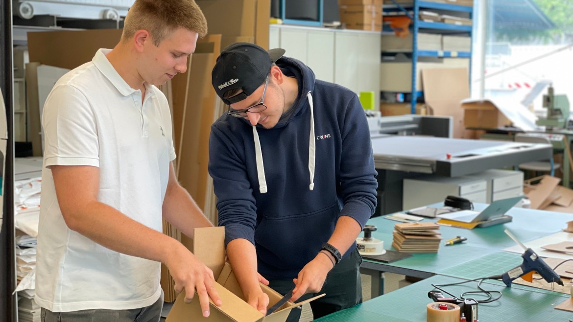 Studierende der Verpackungstechnik mit Karton