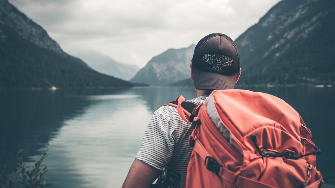 Junger Mann vor Berglandschaft