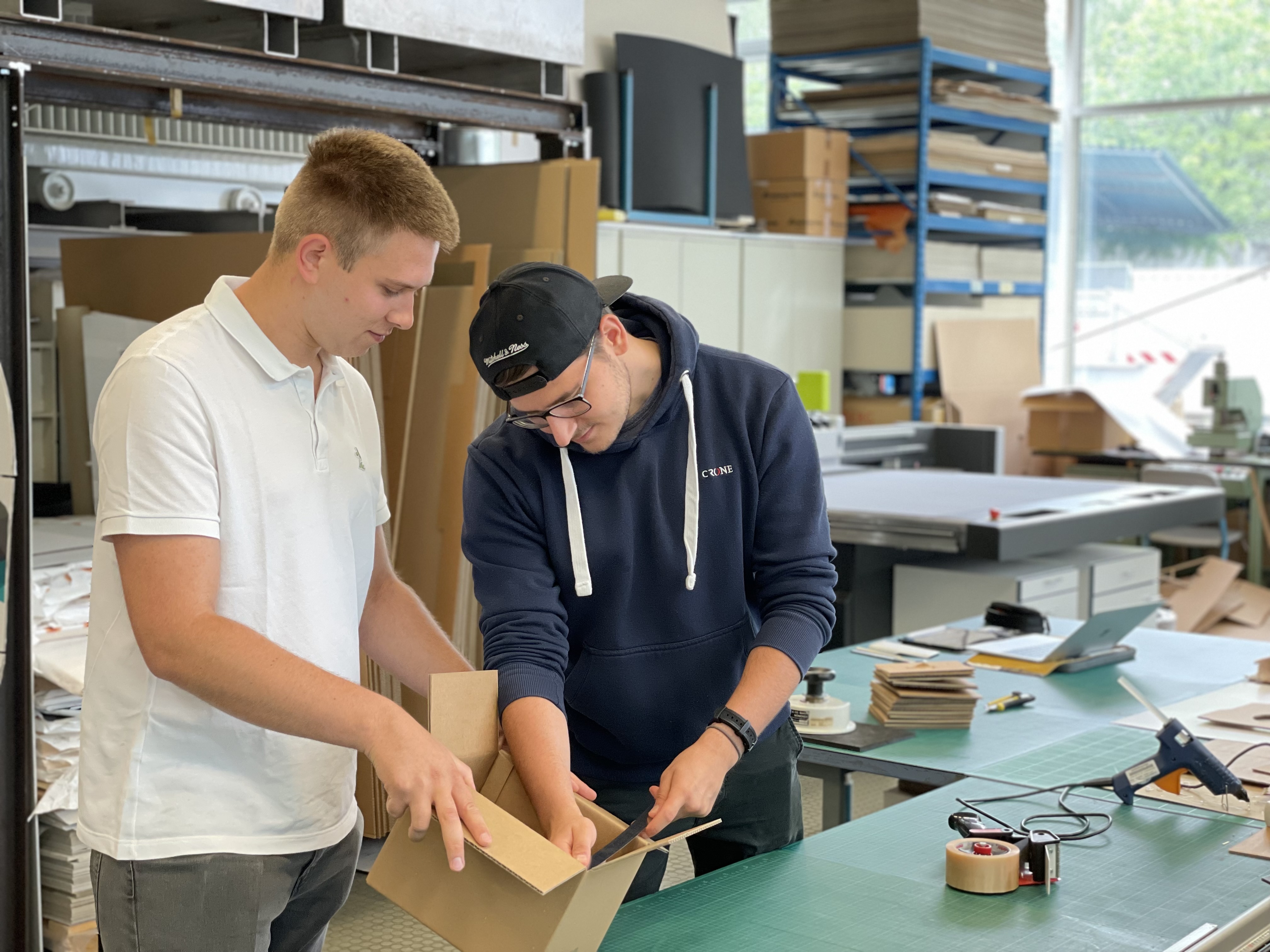 Studierende der Verpackungstechnik mit Karton