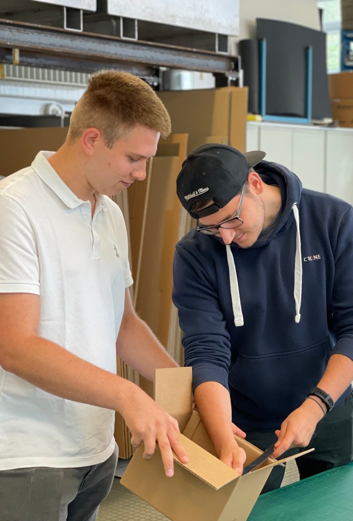 Studierende der Verpackungstechnik mit Karton