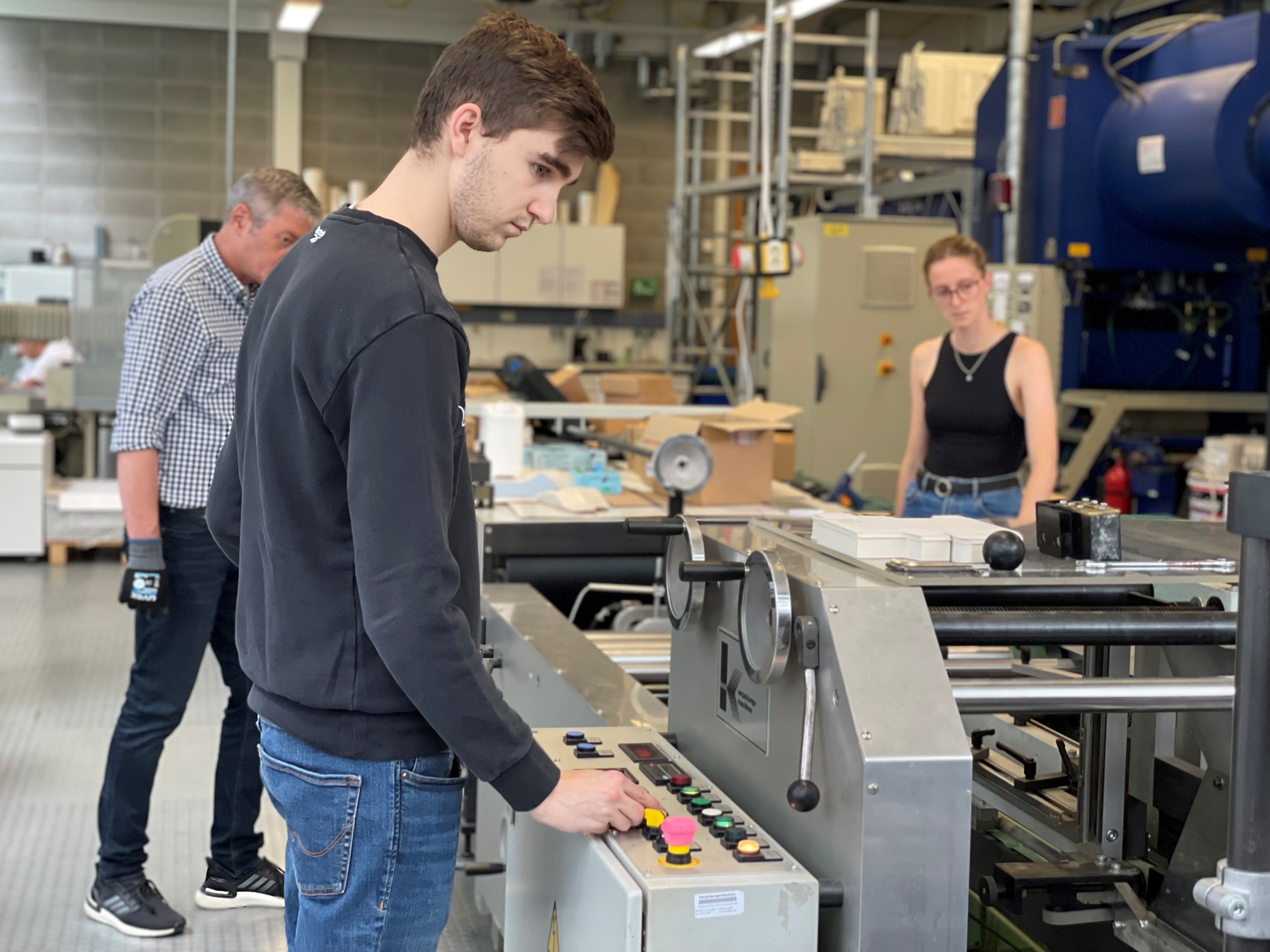 Professor und Studierende der Verpackungstechnik an einer Maschine 