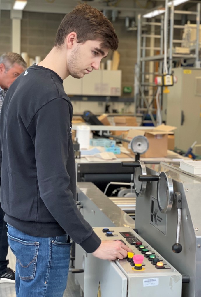 Professor und Studierende der Verpackungstechnik an einer Maschine 