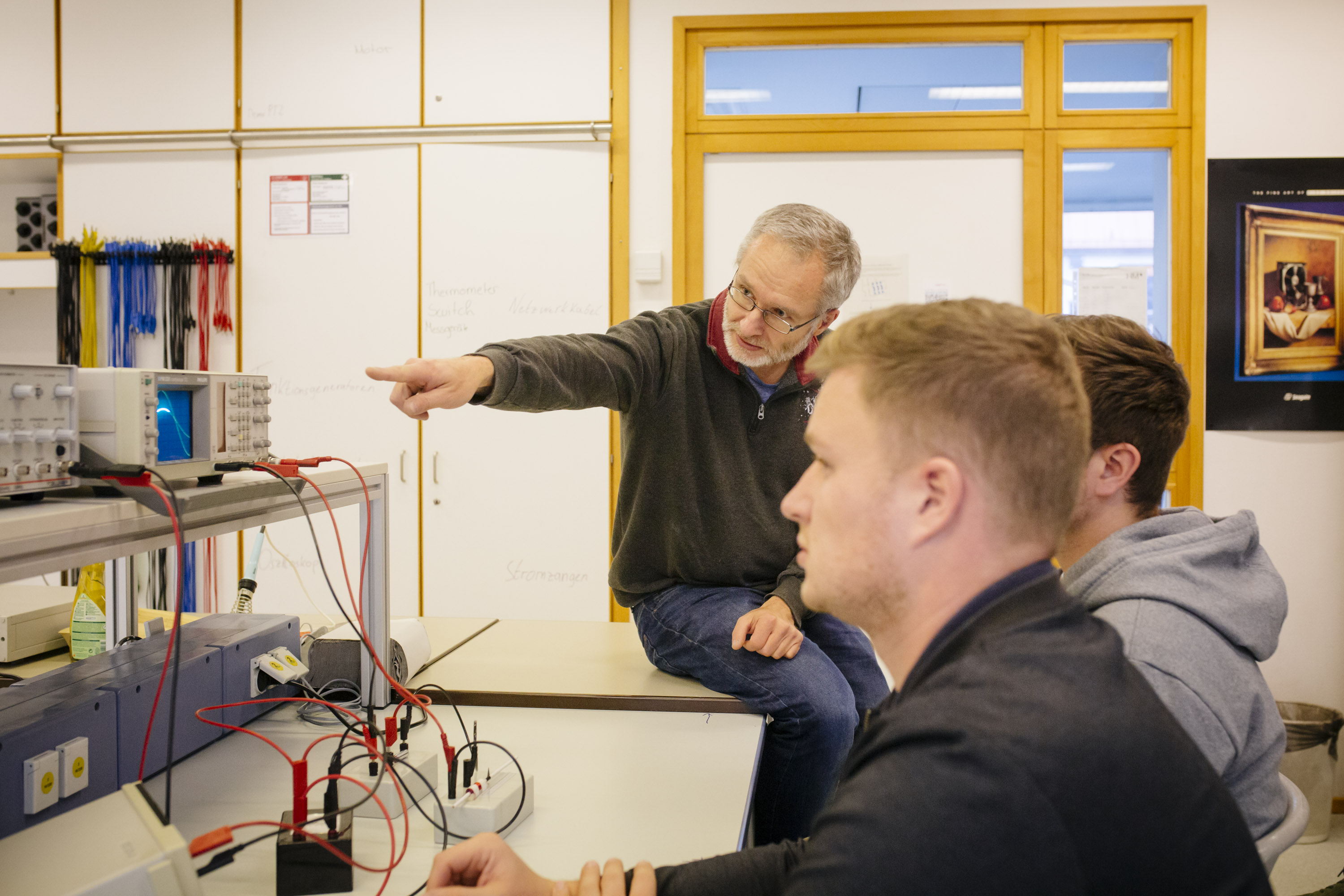 Professor und Studierende im Labor für elektrische Systeme