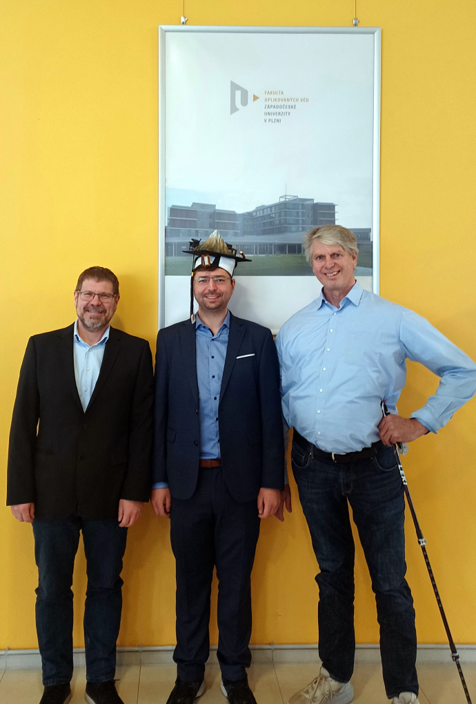 Promotion David Redka: Personen auf dem Bild (von links nach rechts): Prof. Dr. Ján Minár (Betreuer, Westböhmische Universität Pilsen), David Redka mit Doktorhut, Prof. Dr. Heinz P. Huber (Betreuer, Laserzentrum, Hochschule München)