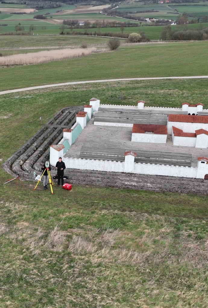 Student mit Messinstrument vor Mini-Kastell