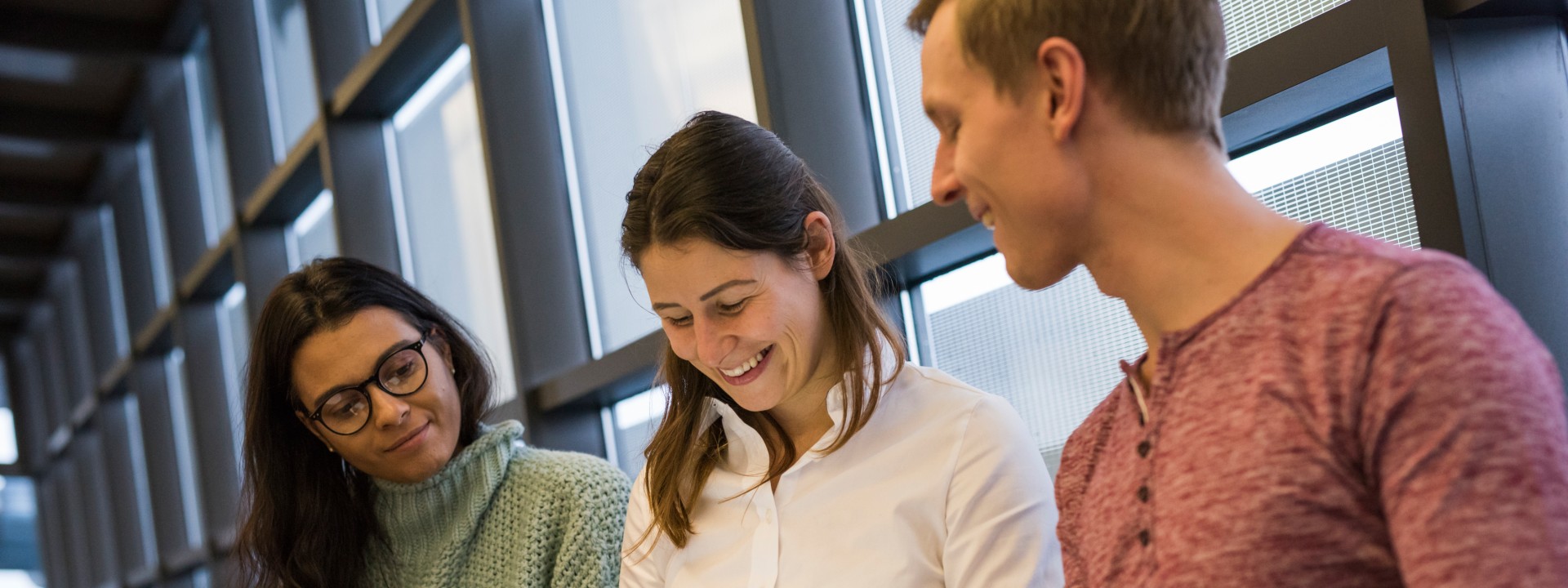 Ein männlicher und zwei weibliche Studierende des MBA & Engineering sitzen nebeneinander. 