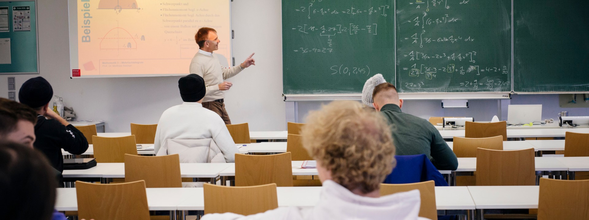 Studierende in einer Vorlesung mit Blick zur Tafel