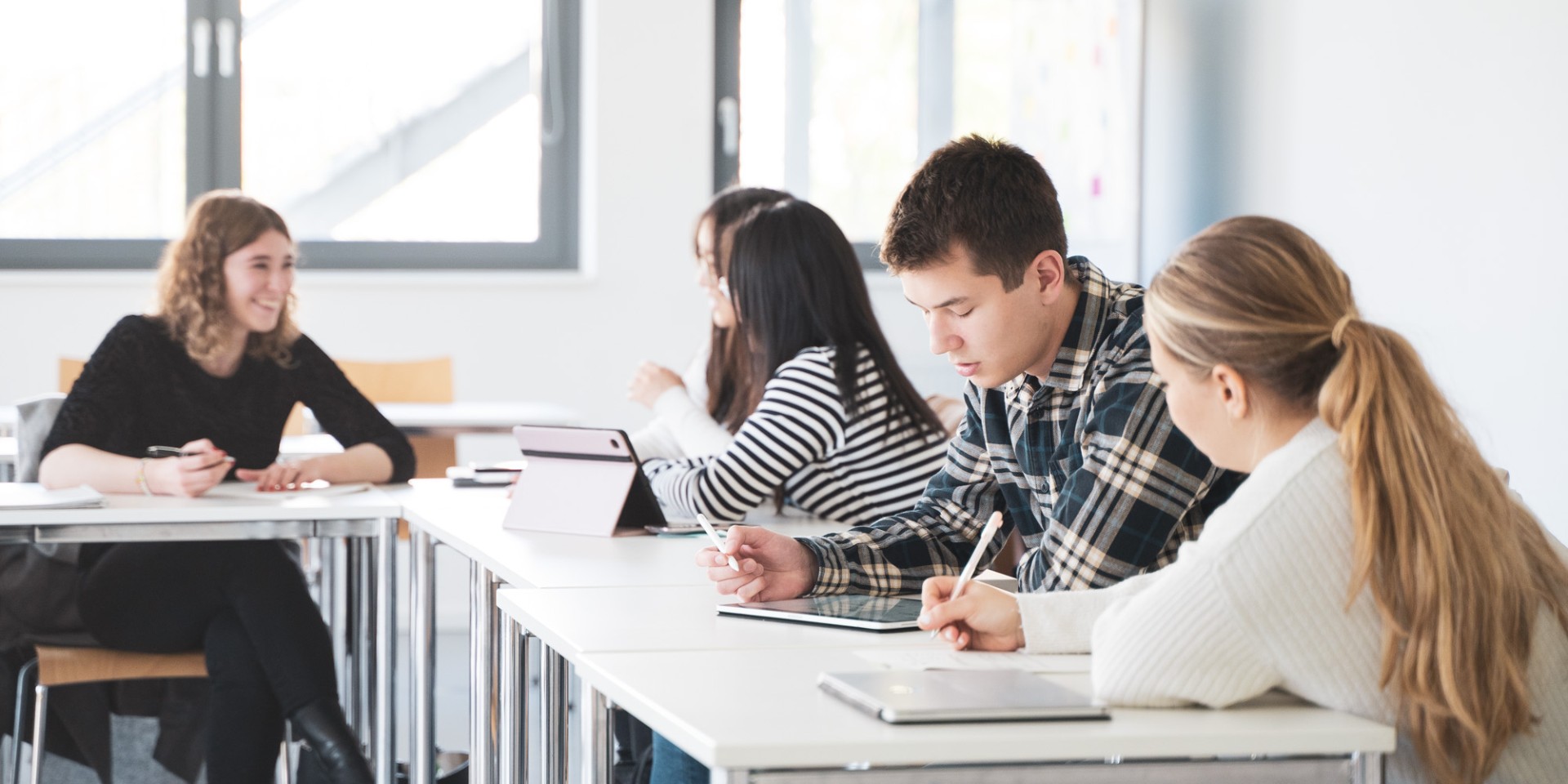 Studierende an Tisch lernend, T-Bau