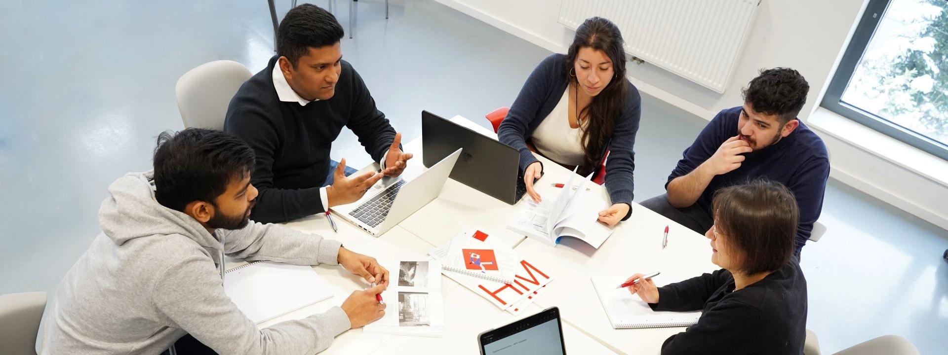 Gruppe von Studierenden arbeitet an einem Tisch