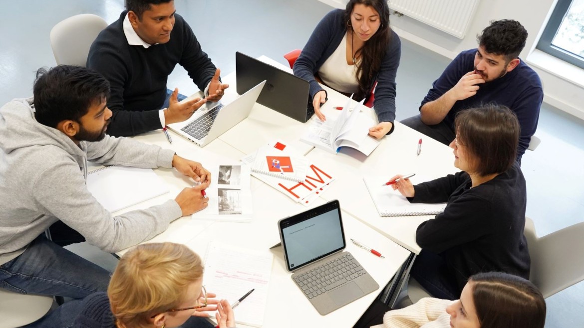 Gruppe von Studierenden arbeitet an einem Tisch